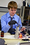  Danville Lutheran middle school student makes an adjustment while printing a 3D image.